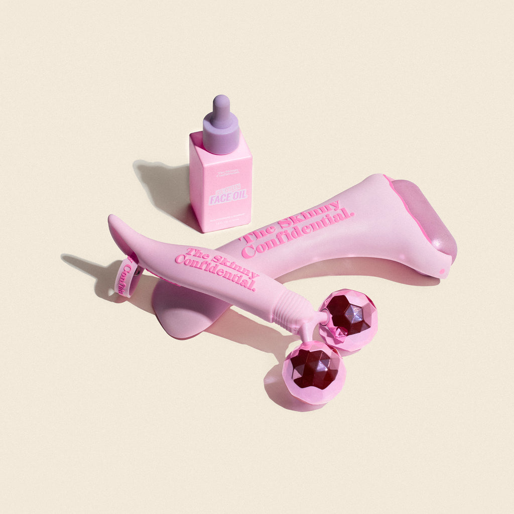 Pink skincare tools and face oil from The Skinny Confidential.