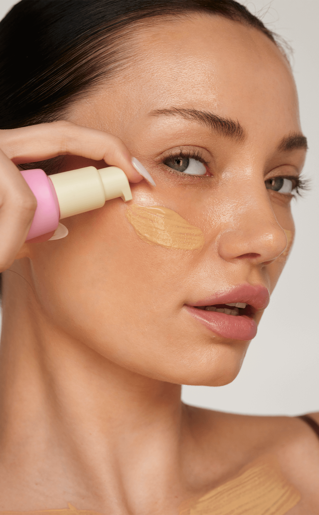 woman applying foundation makeup face beauty routine